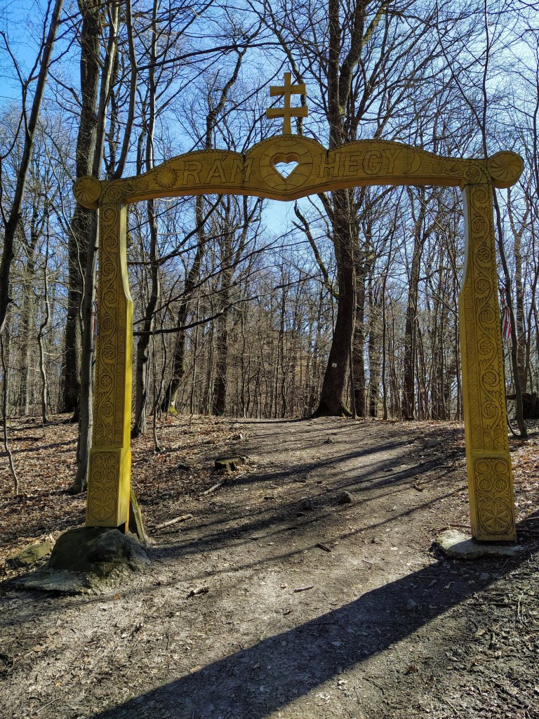 Yellow wooden gate marking the entrance of the Rám hill